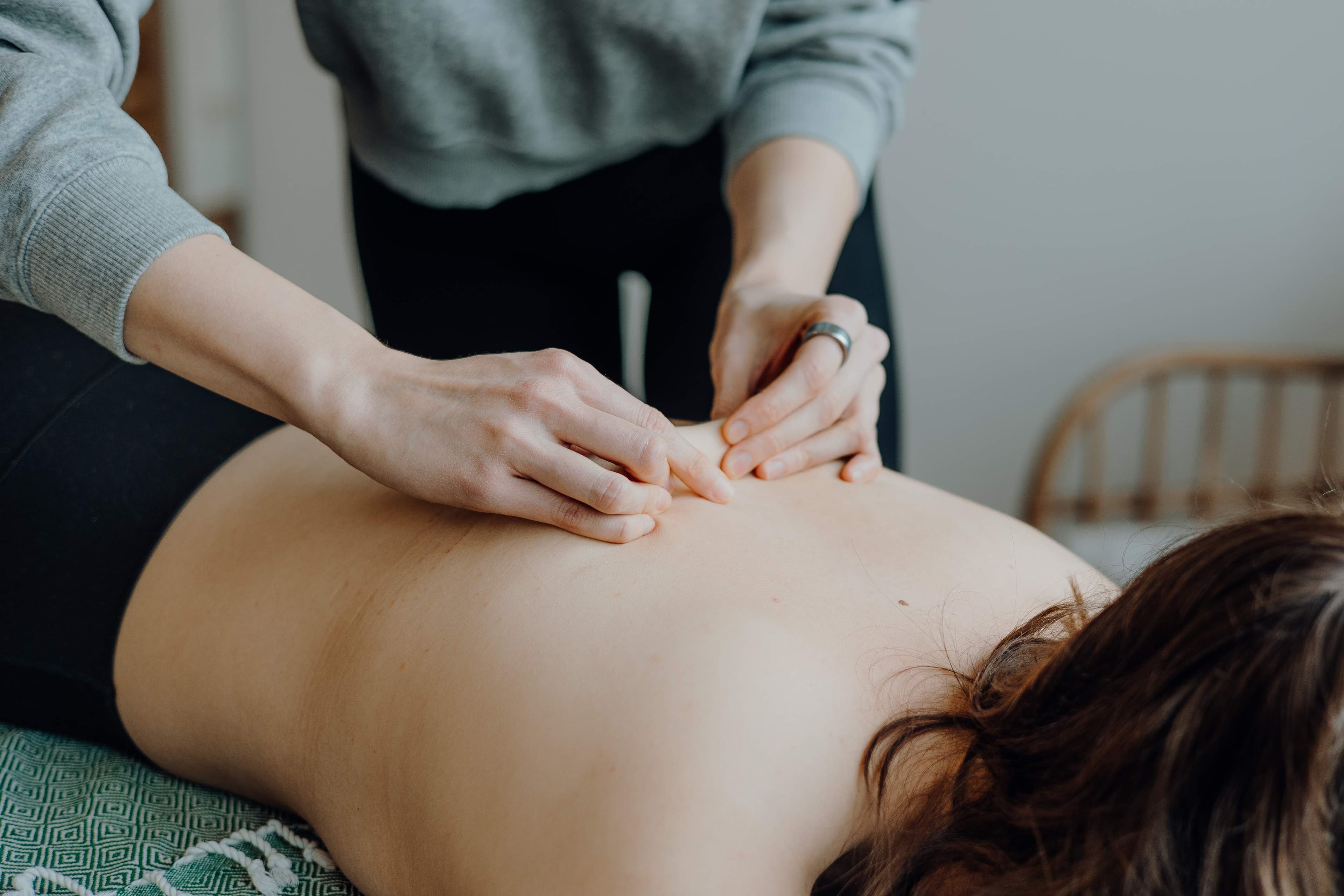 Physiotherapeutin behandelt das Bein eines Patienten auf der Liege